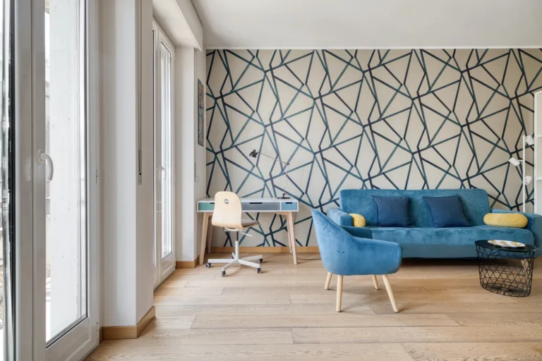 Soggiorno luminoso di un appartamento per affitti brevi a Milano con divano blu e scrivania — esempio di descrizione annuncio casa vacanze